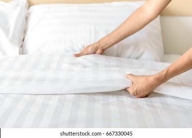 Hand Set Up White Bed Sheet In Room