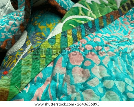Hand Sewing Binding to the Back of a Quilt. Sewing Hobby Concept. Handmade Mobile Photo, Selective Focus, Harsh Sunlight, Not AI