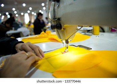 Hand sewing a material on a machine.