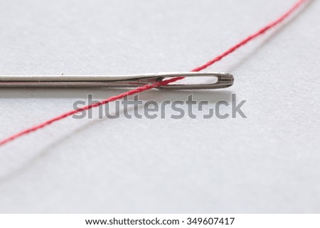 hand sewing needle with red thread bobbin