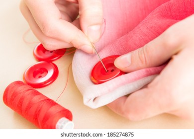 Hand Sewing Red Button On Fabric