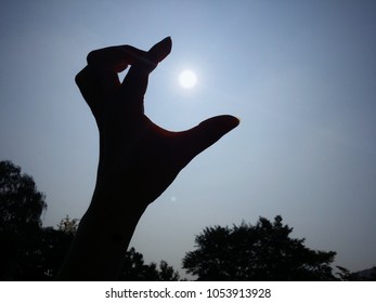 Hand Shadow Has The Shape Of Dragon Head Swallowing The Sun.