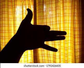 Hand Shadow Pupet With Vibrant Yellow Background, Hand Gesture Silhoutte, Barking Dog.