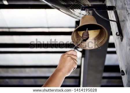 Hand is shaking bell hanging on pole of the boxing stadium.