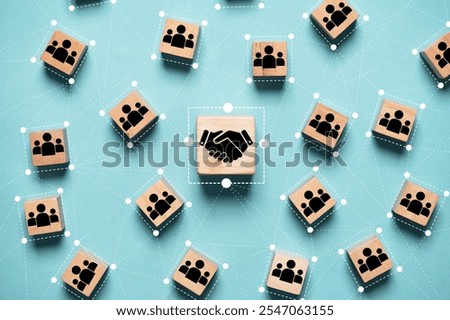 Hand shaking icon print screen on wooden block cube and linkage with people icon for corporate and business deal agreement concept.