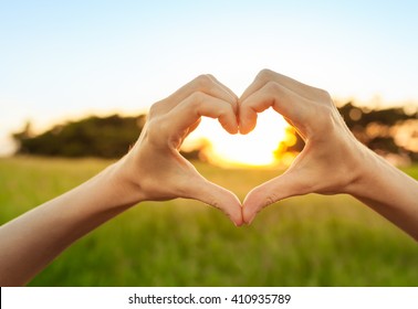 Hand Shaped Heart Against A Beautiful Sunset. 