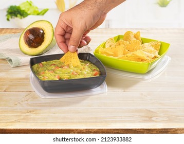 Hand Sharing A Guacamole Dip With Tortilla Chips