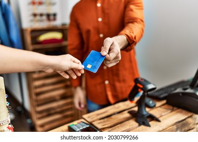 Hand Of Shopkeeper Man Giving Credit Card To Customer At Clothing Store.