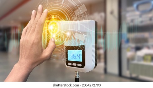 Hand show up of The entrance door with Digital thermometer temperature scanning machine before walk in the store in situations disease COVID-19 virus. - Shutterstock ID 2054272793