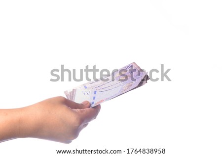 Hand showing 100 Ringgit Malaysia (MYR) money with over white  background and selective focus.