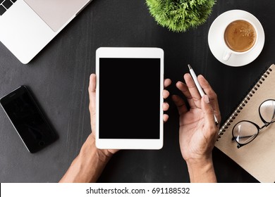 Hand, die einen leeren Bildschirm für digitale Tablette am Arbeitsplatz zeigt
