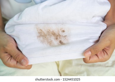 Hand Showing Dirty Mud Stain On White Cloth Shirt For Cleaning Concept 