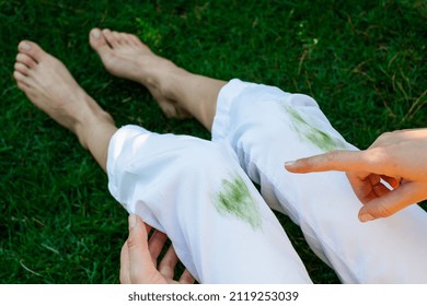 Hand showing dirty stain of grass on white pants from unexpected accident. top view. daily life stain concept. outodoors - Shutterstock ID 2119253039