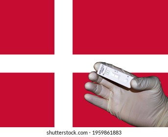 A Hand Showing A Negative Antigenic Corona Rapid Test In Front Of A Flag Of Denmark.