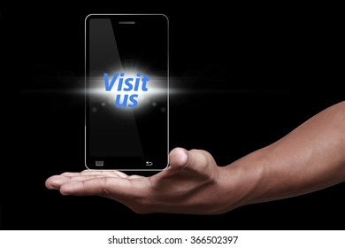 Hand Showing Smartphone With Visit Us Icon
