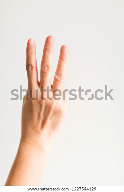 A hand showing three fingers (index finger, middle\
finger and ring finger) on white background for symbol that\
counting number three.