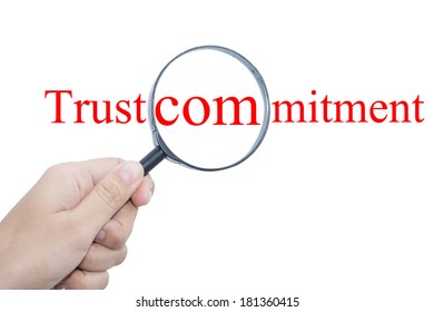 Hand Showing trust commitment Word Through Magnifying Glass 