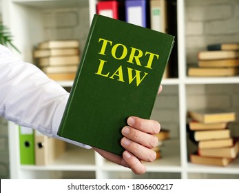 Hand Shows A Tort Law Book In The Office.