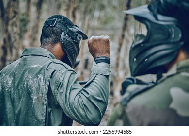 Hand sign, man and paintball training by friends for planning, strategy and plan of action outdoor. Military, men and fist of guy leading team in sports, shooting and intense target practice together