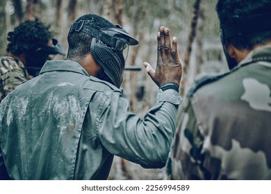 Hand sign, stop and men in training, paintball and planning, strategy and plan of action outdoor. Military, men and hands by guy leading team in sports, shooting and intense target practice together