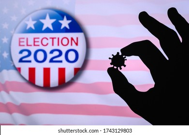 Hand Silhouette Hold Covid 19 Virus. Logo Of USA Presidental Election 2020 In Background. US Presidential Elections Are Threatened By Coronavirus And May Be Postponed