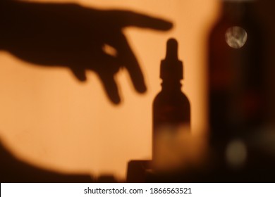 Hand silhouette pick up Dropper Bottle. Cosmetic brand concept. Cbd oil