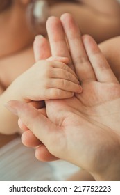 hand the sleeping baby in the hand of mother close-up. hand the sleeping baby in the hand of mother close-up - Shutterstock ID 217752223