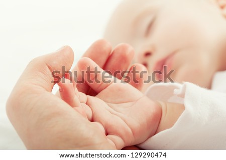 hand the sleeping baby in the hand of mother  close-up