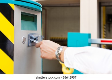 Hand Is Slipping Parking Ticket Into Barrier Of The Parking Garage, Close-up