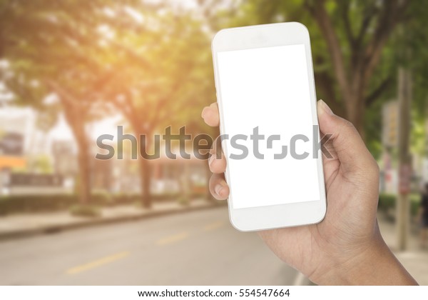 Hand with smartphone on the\
road. 