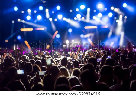 Hand with a smartphone records live music festival, Taking photo of concert stage, live concert, music festival, happy youth, luxury party, landscape exterior. Foto stock © 