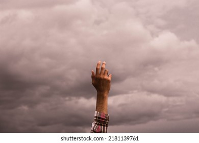 hand with soft light touching the cloudy sky