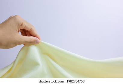Hand Soft touch natural fabric. Close-up of the hand holding the cloth. Selection of natural linen Textures for design Linen texture for background. The image has a shallow depth of field. Satin backg