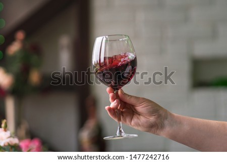 Hand sommelier holding glass of red wine. Swirling red wine glass in wine tastings. Wine tour. Space for text.
 Zdjęcia stock © 