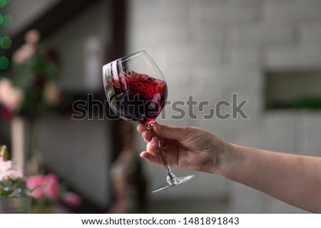 Hand sommelier holding glass of red wine. Swirling red wine glass in wine tastings. Wine tour. Space for text.
 Foto stock © 