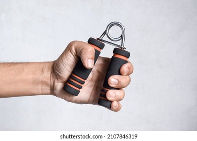 Hand of Southeast asian, Chinese man gripping hand exercise gripper.