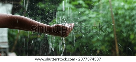hand with splashes of rain falling close up