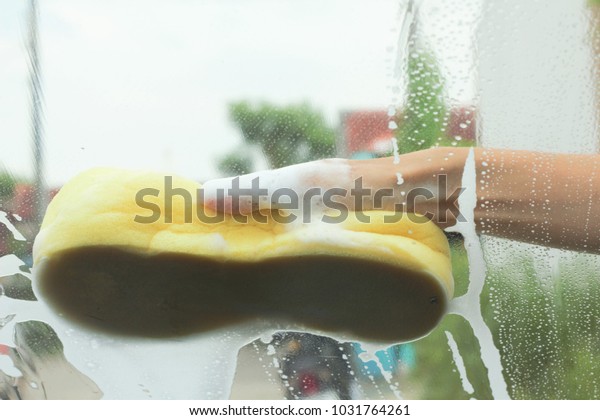 Hand with a sponge to clean window glass of car\
inside car view