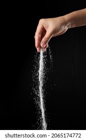 Hand Sprinkling Brown Sugar Isolated On Black Background