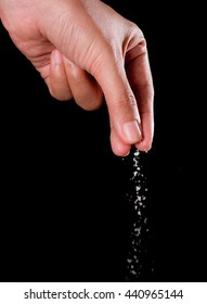 Hand Sprinkling Salt,salt Over Black Background.