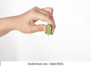 Hand squeeze green lime with lime drop isolated on white background.