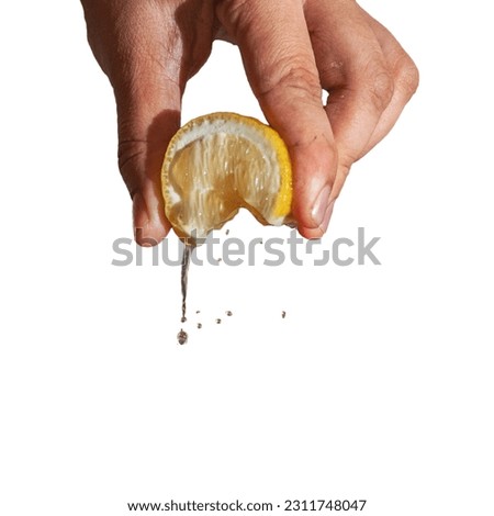 Hand squeeze lemon with lemon juice drop isolated on white
