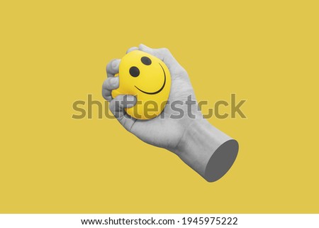 Hand squeeze yellow stress ball, isolated on yellow background