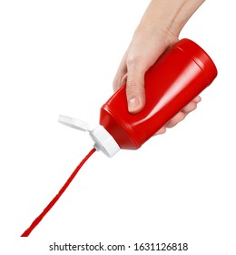 Hand squeezing ketchup out of a plastic bottle, isolated on white background