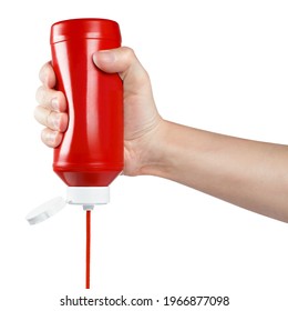 Hand squeezing ketchup out of a plastic bottle, isolated on white background