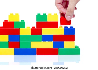 hand stack up lego set as a wall on white background