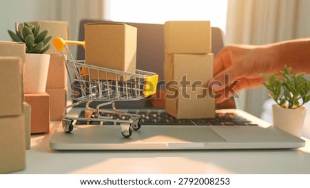 A hand stacking boxes in layers reflects bulk purchasing from e-commerce, emphasizing digital shopping trends, efficient logistics, consumer demand, and online business growth.
