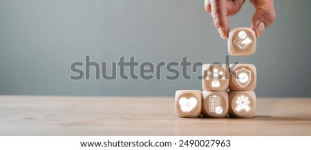 Hand stacking wooden blocks with icons symbolizing trust, quality, and reliability, illustrating the concept of building credibility in business or personal relationships.