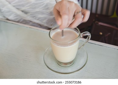 Hand Stirring A Cup Of Hot Caramel Milk