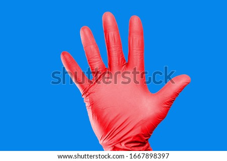 Hand stop gesture. Red latex glove isolated. Five fingers palm open hand. Higiene virus protection background.
